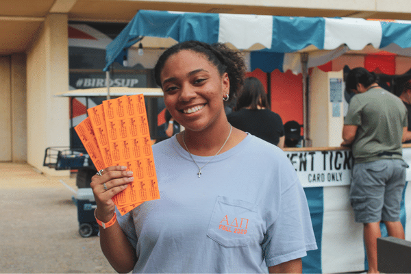 student holding ticket at ticket booth